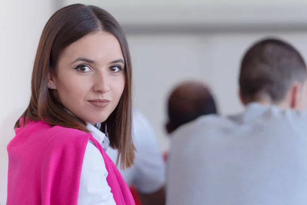 Retrato de uma estudante feliz sentada na mesa em univer — Fotografia de Stock