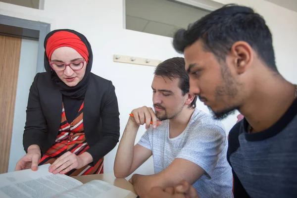 Profesora musulmana mujer explicar lección a los estudiantes e interactuar —  Fotos de Stock
