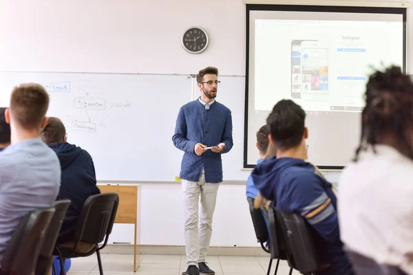 Profesor masculino explicar lección a los estudiantes e interactuar con ellos —  Fotos de Stock