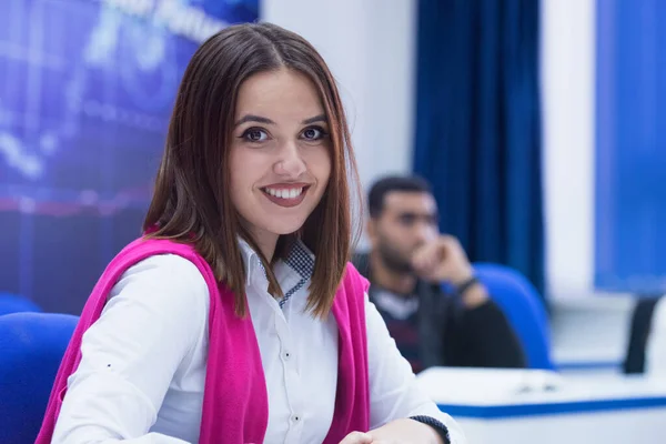 Universitaria estudiante en clase se sienta en su escritorio girando a s —  Fotos de Stock