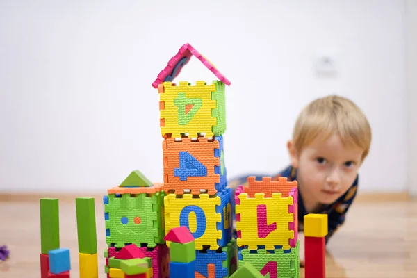 Criança pré-escolar brincando com blocos de brinquedos coloridos. Miúdo a brincar — Fotografia de Stock