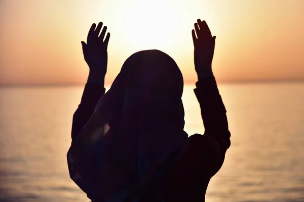 Moslim vrouw bidden in het schip bidden bij zonsondergang met handen omhoog — Stockfoto