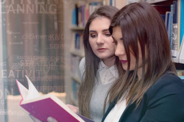 Δύο όμορφες ενήλικες γυναίκες διεθνείς φοιτητές ξοδεύουν διάλειμμα στη βιβλιοθήκη του πανεπιστημίου — Φωτογραφία Αρχείου