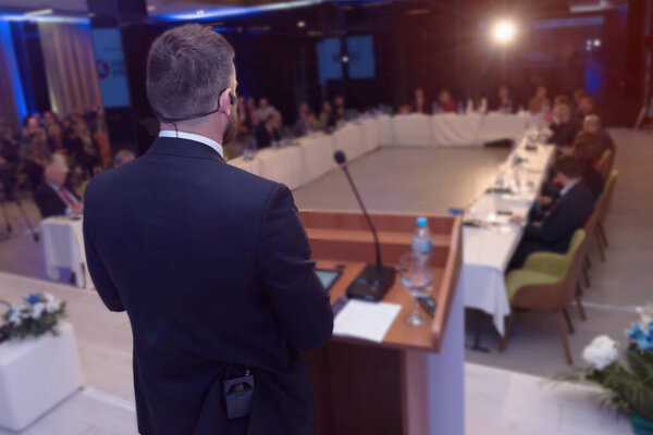 Young businessman at business conference room with public giving