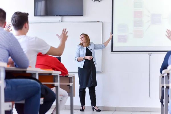 Vrouwelijke professor leggen les aan studenten en interactie met th — Stockfoto