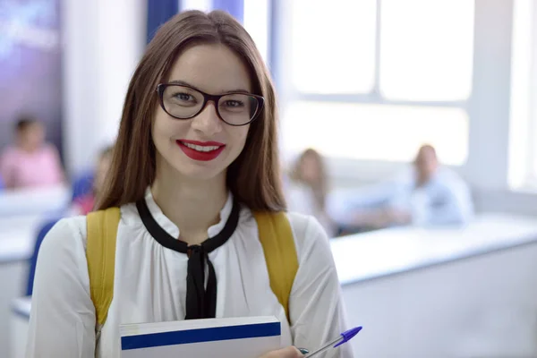 Üniversitede duran gözlüklü güzel bir kız öğrenci. — Stok fotoğraf