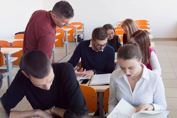 Profesor masculino explicar lección a los estudiantes e interactuar con ellos —  Fotos de Stock