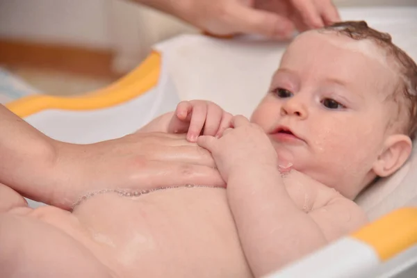 Söta tre månader liten flicka tar ett bad med sin mamma hemma, europeiskt barn. — Stockfoto