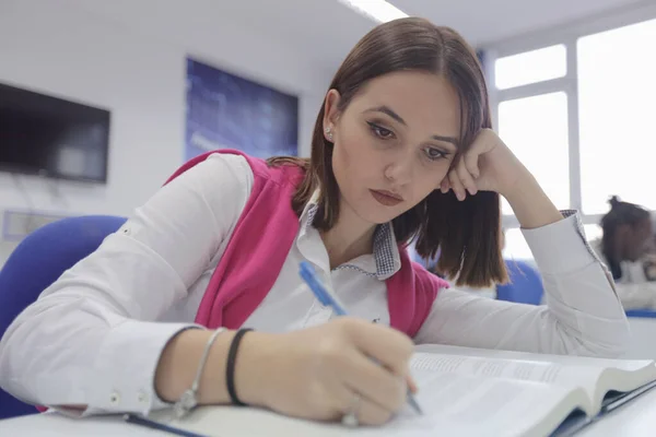 Mooie femele student maakt aantekeningen in de klas. — Stockfoto