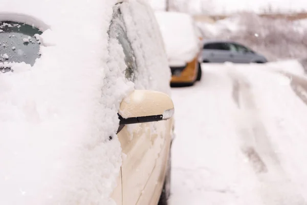 通り側には雪に覆われた車が駐車していた。雪の下の車 — ストック写真