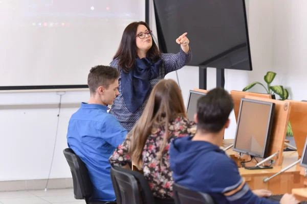 Vrouwelijke professor leggen les aan studenten en interactie met th — Stockfoto
