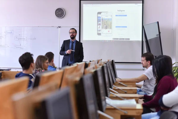 Professor do sexo masculino explicar lição para os alunos e interagir com eles — Fotografia de Stock