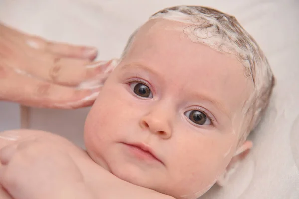 Hübsches drei Monate altes Mädchen, das von seiner Mutter zu Hause gebadet wird, europäisches Kind. — Stockfoto