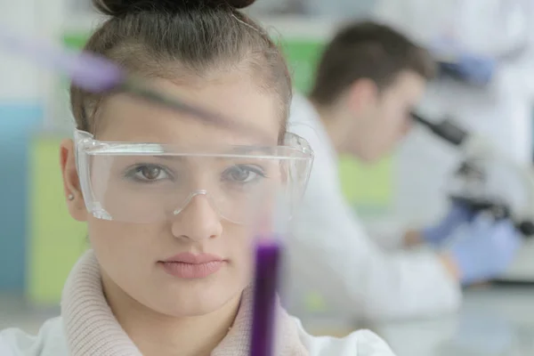 Laboratuvarda test tüpleri ve mikroskopla çalışan iki genç kadın ve erkek bilim adamı., — Stok fotoğraf