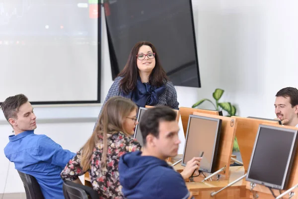 Ženská profesorka vysvětlit lekci studentům a komunikovat s ní — Stock fotografie