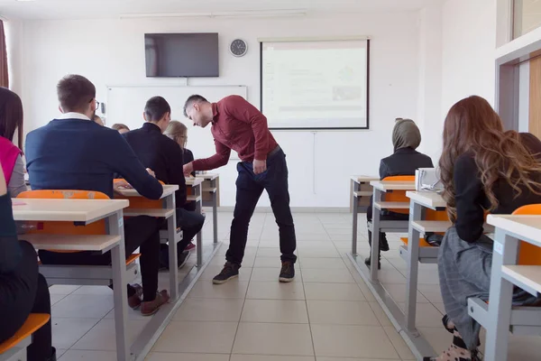 Professor do sexo masculino explicar lição para os alunos e interagir com eles — Fotografia de Stock