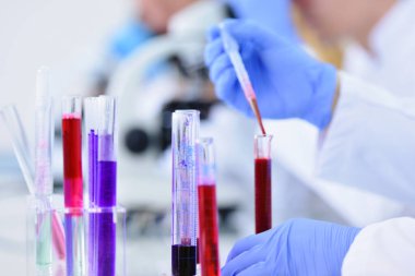 Laboratuvarda test tüpleriyle çalışan genç bir bilim adamı.