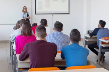 Çekici kadın profesör öğrencilere ve öğrencilere ders veriyor.