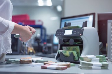 Banka çalışanları banka kasasında para sayıyor ve sıralıyor. Lar