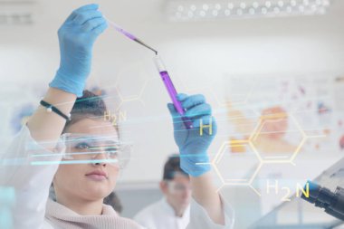 Laboratuvarda test tüpleri ve mikroskopla çalışan iki genç kadın ve erkek bilim adamı.,