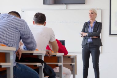 Çekici kadın profesör öğrencilere ve öğrencilere ders veriyor.