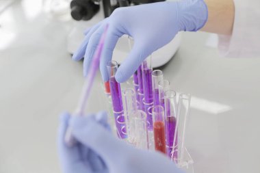 Laboratuvarda test tüpleriyle çalışan genç kadın laboratuvar bilim adamı.