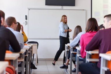 Bayan profesör öğrencilere dersi açıkla ve onunla iletişim kur.