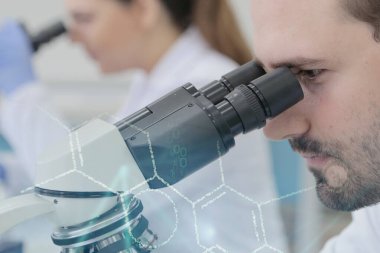 Laboratuvarda deney tüpleriyle çalışan iki genç bilim adamı...