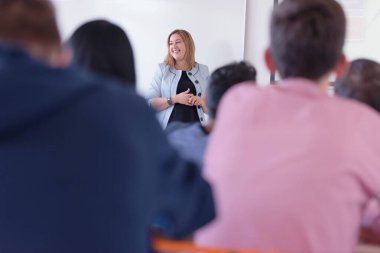 Bayan profesör öğrencilere açıkla ve onlarla iletişim kur.