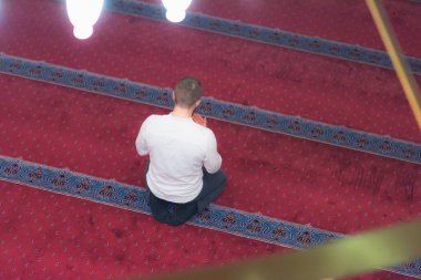 Genç, dindar, Avrupalı Müslüman adam bu güzel adamın içinde dua ediyor.