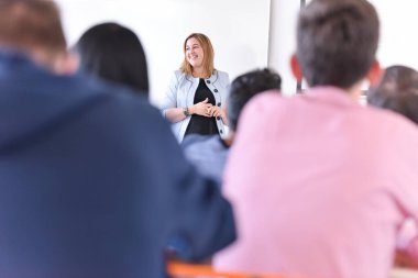 Bayan profesör öğrencilere dersi açıkla ve onunla iletişim kur.