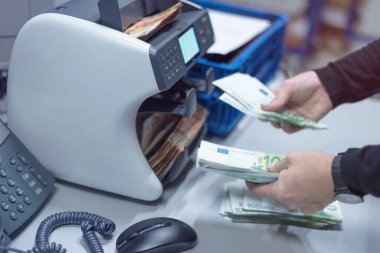 Banka çalışanları banka kasasında para sayıyor ve sıralıyor. Lar