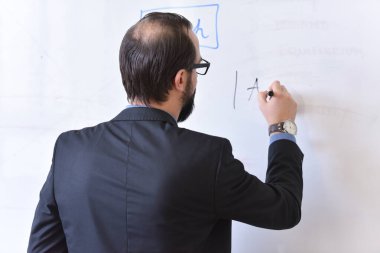 Erkek profesör öğrencilere ders veriyor ve onlarla iletişim kuruyor.