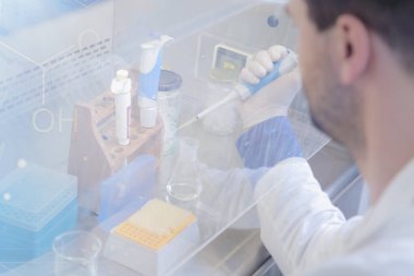 Laboratuvarda test tüpleriyle çalışan genç bir bilim adamı.