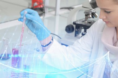 Laboratuvarda test tüpleriyle çalışan genç kadın laboratuvar bilim adamı.