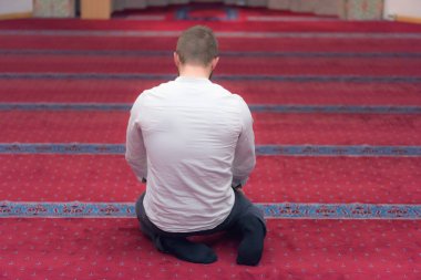 Genç, dindar, Avrupalı Müslüman adam bu güzel adamın içinde dua ediyor.