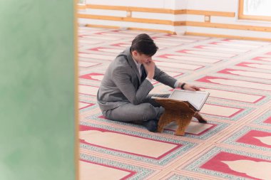 Dindar genç hafiz müslüman adam caminin içinde dua ediyor.