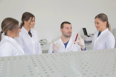 Laboratuvarda test tu ile çalışan bir grup genç bilim adamı.