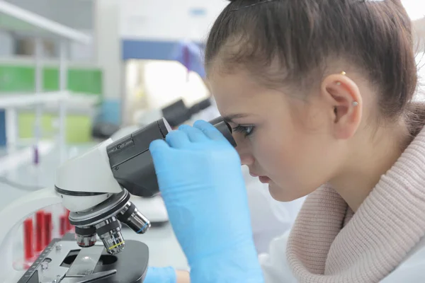 Ung kvinnlig laboratorieforskare som arbetar på labb med provrör — Stockfoto