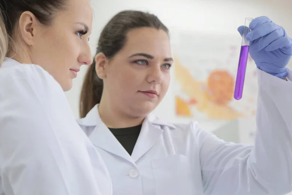 Twee jonge vrouwelijke laboratoriumwetenschappers werken in het lab met een test — Stockfoto
