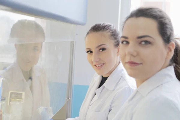 Dos jóvenes científicas de laboratorio trabajando en el laboratorio con la prueba —  Fotos de Stock