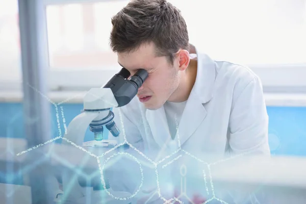 Joven científico de laboratorio masculino que trabaja en el laboratorio con tubos de ensayo a — Foto de Stock