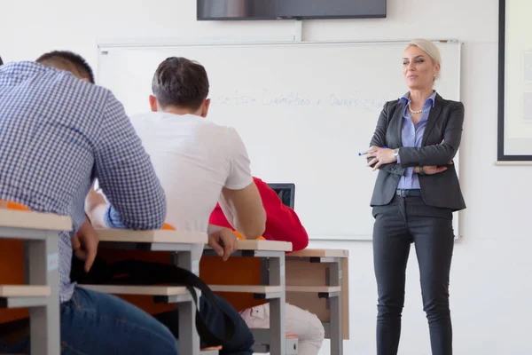 Atraktivní profesorka vysvětlit lekci pro studenty a mimo — Stock fotografie