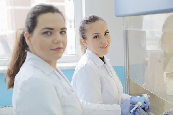 Twee jonge vrouwelijke laboratoriumwetenschappers werken in het lab met een test — Stockfoto