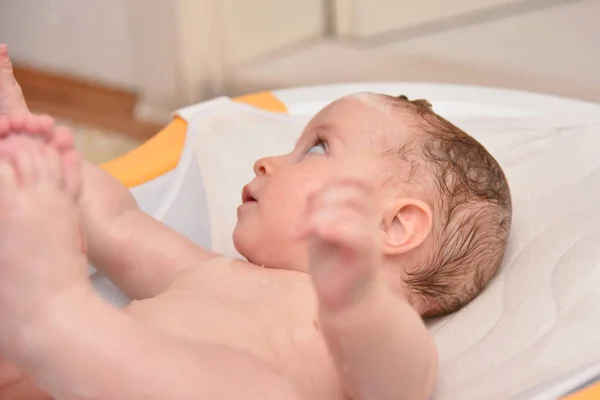 Mooi drie maanden baby meisje nemen van een bad door haar moeder thuis, europese kind. — Stockfoto