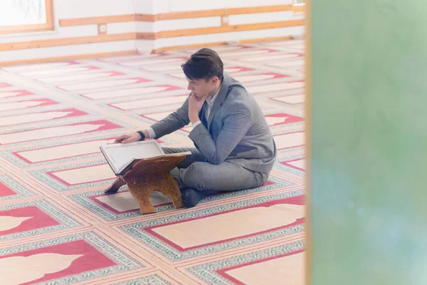 Religiös muslim man be inne i moskén och läsa heliga — Stockfoto