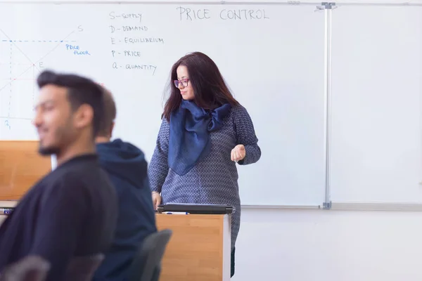 Female professor explain to students and interact with them in t