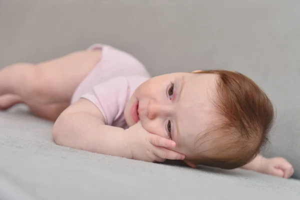 Feliz bebé de tres meses sobre fondo blanco. Niña mintiendo —  Fotos de Stock