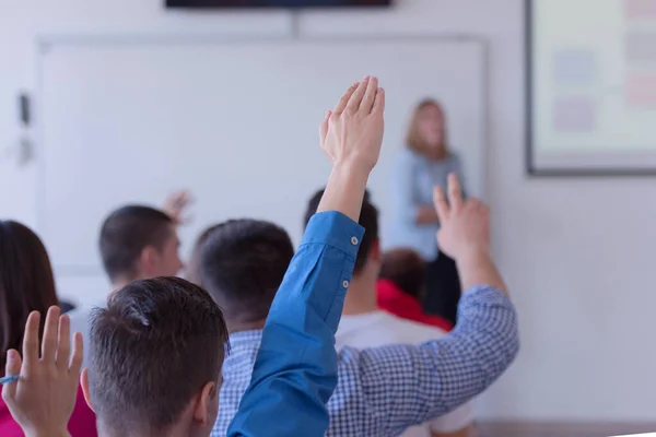 Groep universiteitsstudenten die in de klas zitten en h — Stockfoto