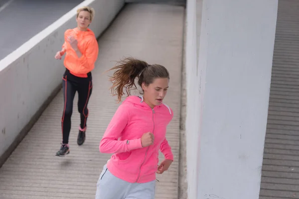 Kapüşonlu Iki Genç Bayan Koşucu Şehir Sokaklarında Koşuyor Formda Vücut — Stok fotoğraf